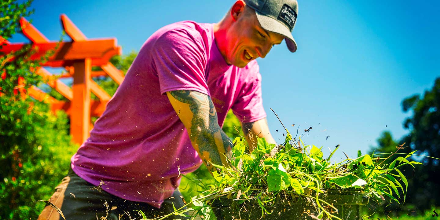 Leaf & Limb team member cleaning brush and leaves