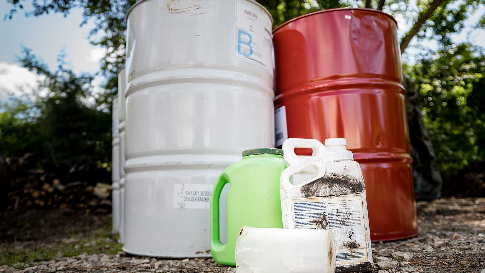 Hand applying chemical fertilizer granules to garden soil