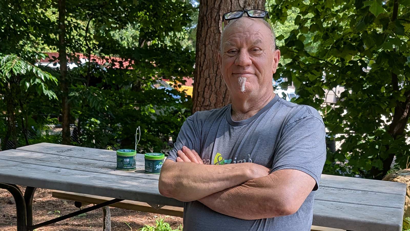 Colin, co-owner of Leaf & Limb, sitting at a picnic table and smiling.