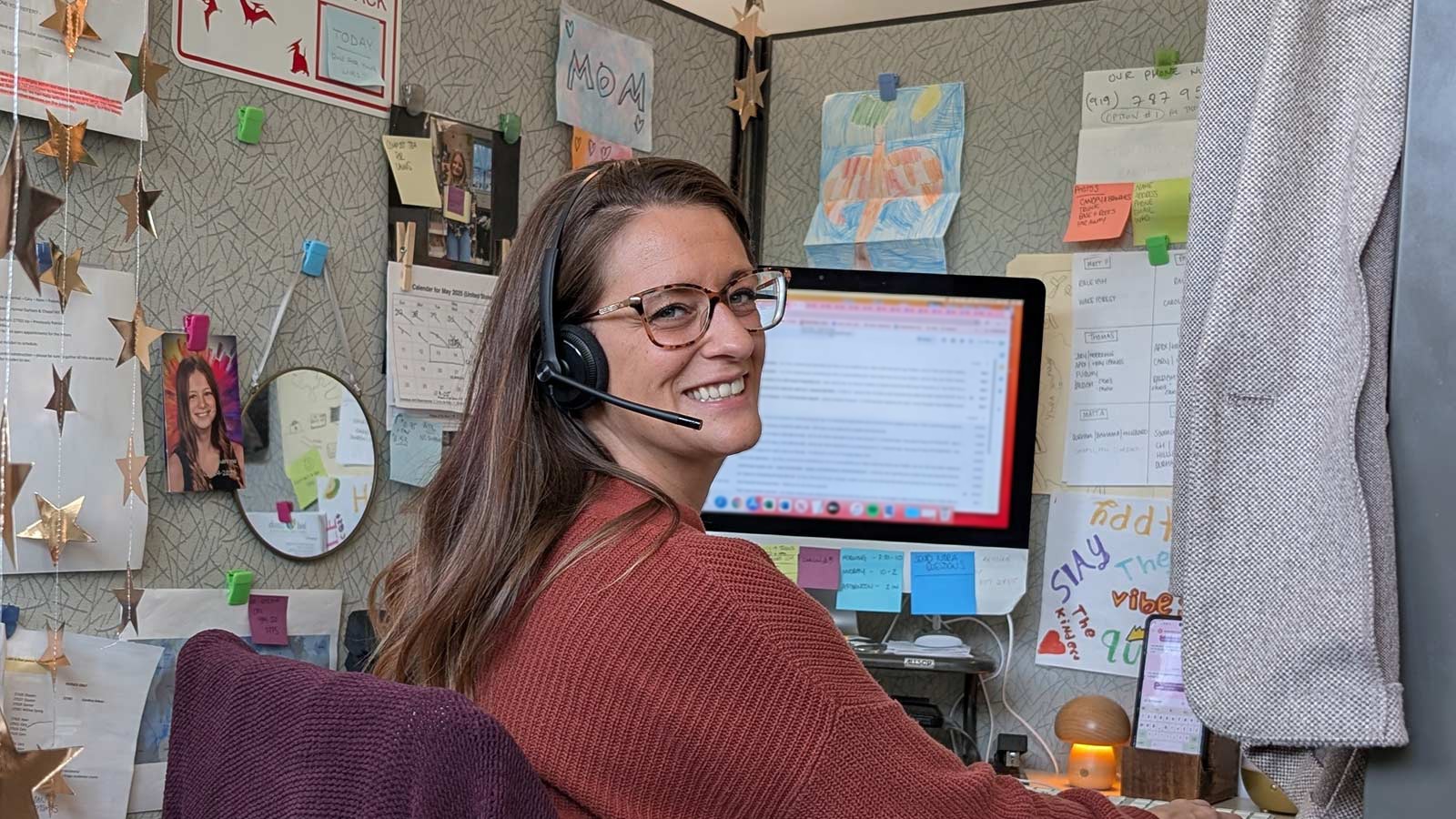 Katrina, a client service rep, smiling at a desk