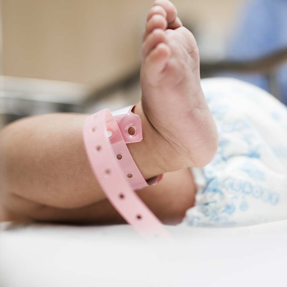 Mother and baby in park with trees, illustrating increased infant birth weight